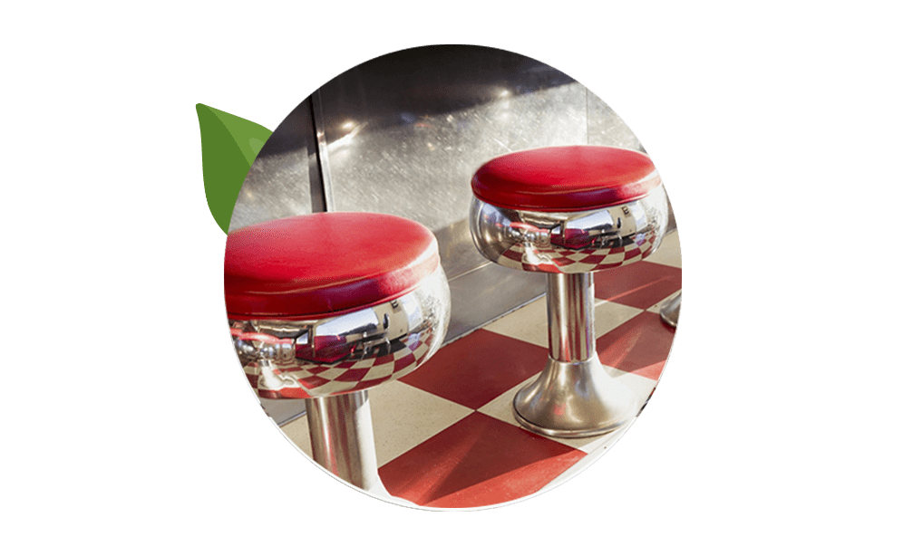 Two chrome diner stools with red seats