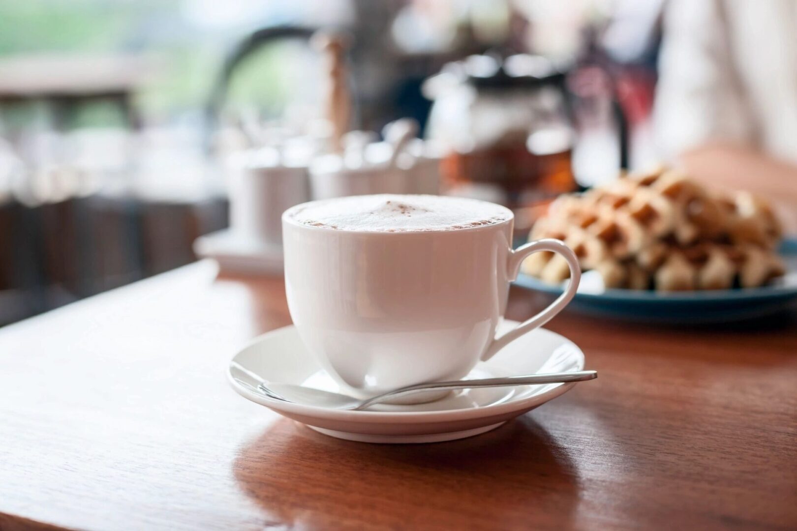 Cup of cappuccino on saucer with spoon
